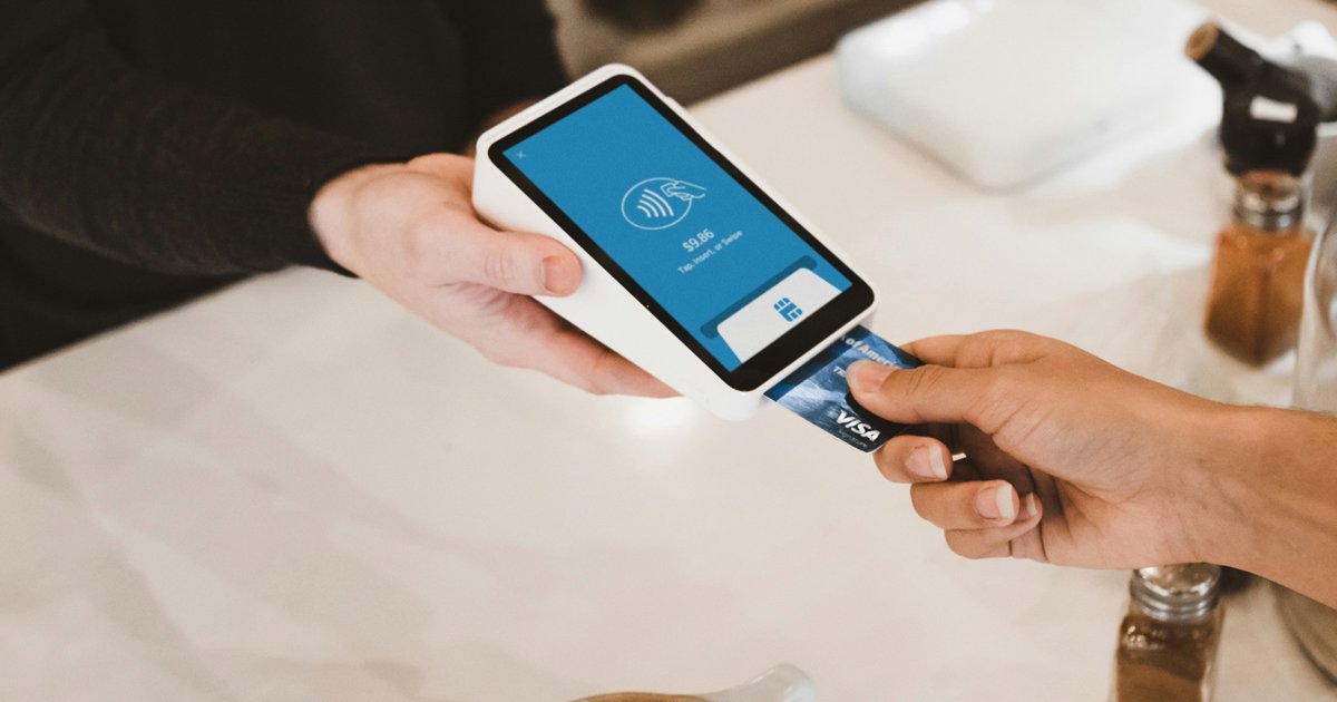 A customer inserting a card into a payment terminal